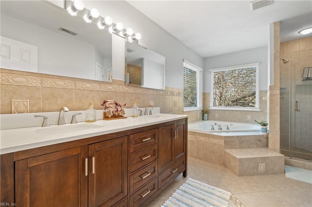 bathroom with a sink, visible vents, a bath, and tile patterned flooring