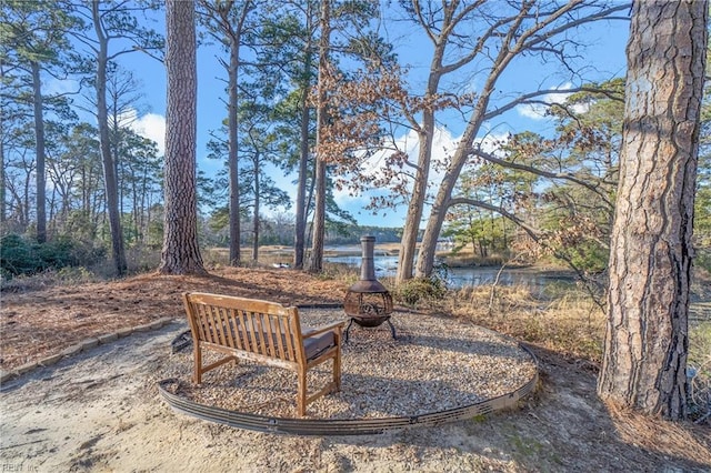 view of yard with a fire pit and a water view