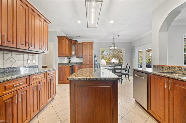 kitchen featuring stainless steel dishwasher, light tile patterned flooring, brown cabinetry, and a center island