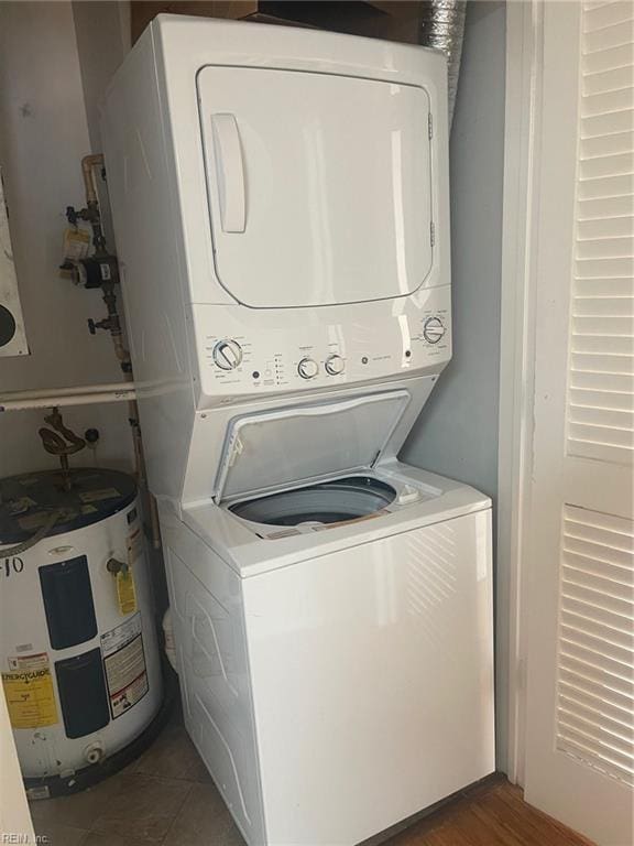 washroom with laundry area, water heater, and stacked washing maching and dryer