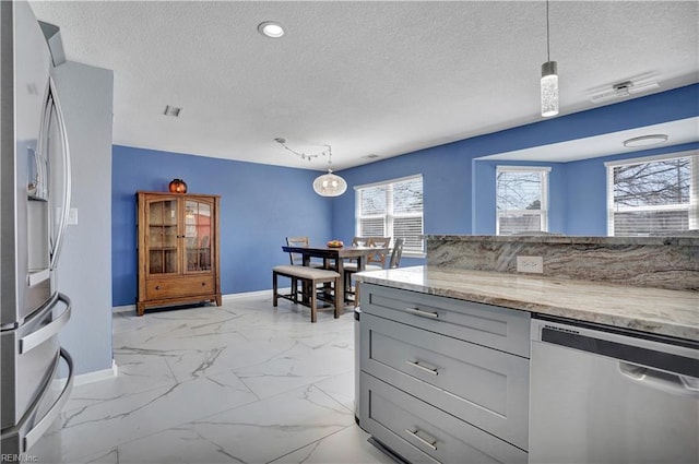 kitchen featuring light stone counters, baseboards, marble finish floor, and appliances with stainless steel finishes