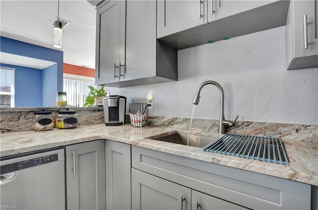 kitchen featuring gray cabinets, dishwasher, a healthy amount of sunlight, and light stone countertops