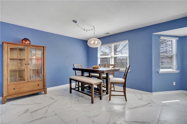 dining space with visible vents, marble finish floor, a textured ceiling, and baseboards