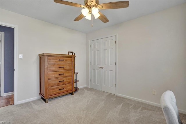 bedroom featuring baseboards, light carpet, a closet, and ceiling fan