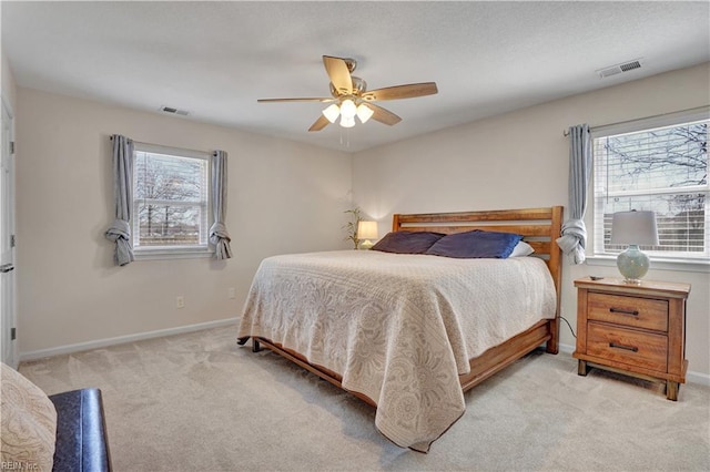 carpeted bedroom with visible vents, multiple windows, and baseboards