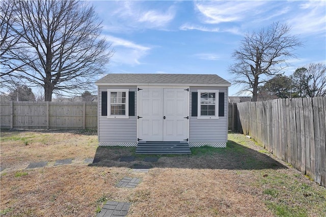 view of outdoor structure featuring entry steps, an outdoor structure, and a fenced backyard