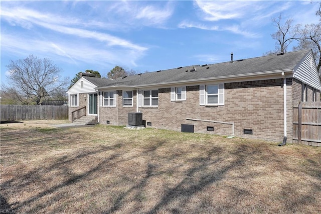 back of property with fence, entry steps, crawl space, a lawn, and brick siding