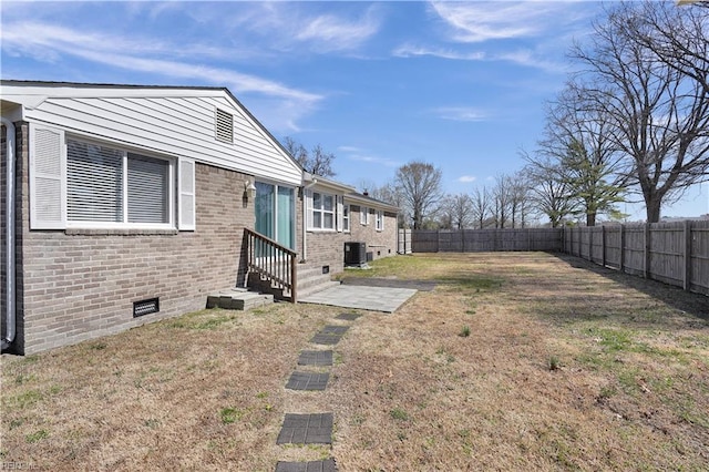 view of yard featuring entry steps, a fenced backyard, and central AC