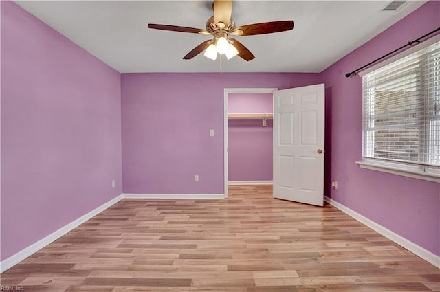 unfurnished bedroom with visible vents, a closet, light wood finished floors, baseboards, and ceiling fan