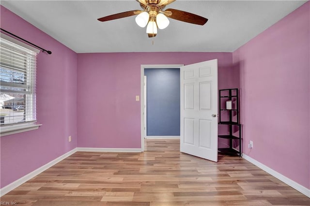 unfurnished bedroom with ceiling fan, light wood-type flooring, and baseboards