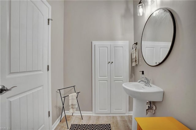 bathroom with wood finished floors and baseboards