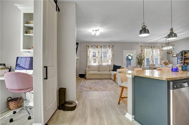 kitchen with stainless steel dishwasher, light wood-style flooring, a healthy amount of sunlight, and light stone countertops