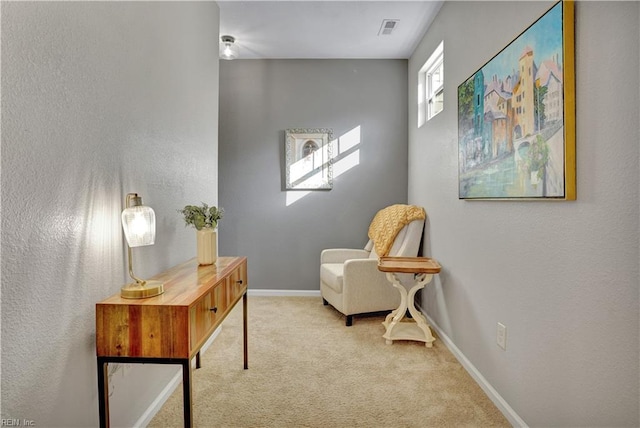 living area featuring visible vents, baseboards, and carpet floors