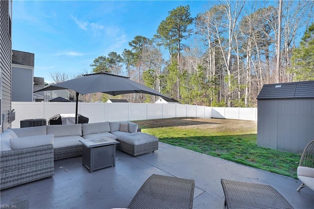 view of patio with area for grilling, a fenced backyard, an outdoor structure, outdoor lounge area, and a storage shed