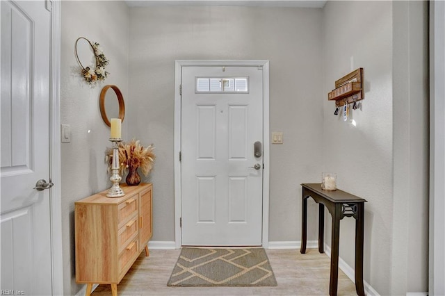 entryway featuring baseboards and light wood finished floors