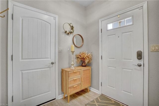 foyer featuring light wood-style floors and baseboards