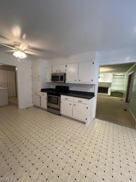 kitchen featuring dark countertops, light floors, white cabinets, and stainless steel appliances