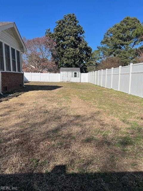 view of yard with a shed, an outdoor structure, and a fenced backyard