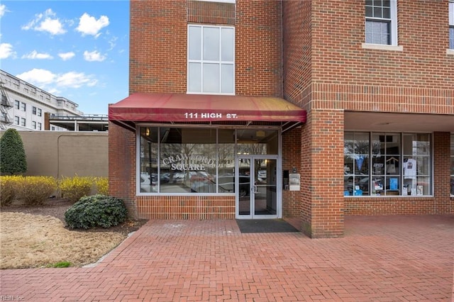 view of exterior entry featuring brick siding