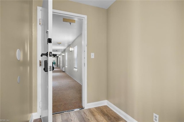 hall featuring baseboards and wood finished floors