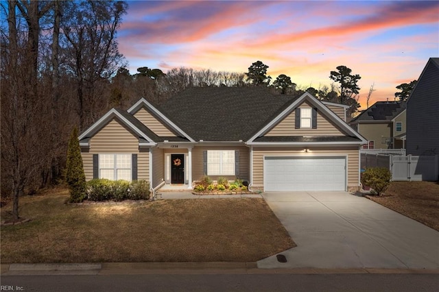 view of front of home with a front lawn, concrete driveway, a garage, and fence