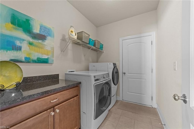 laundry area with light tile patterned flooring, laundry area, washer and clothes dryer, and baseboards