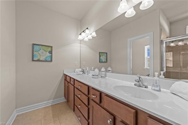 bathroom with tile patterned floors, a sink, a shower stall, double vanity, and baseboards