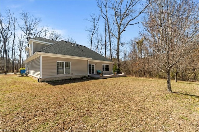 rear view of property featuring a lawn, a shingled roof, and a deck