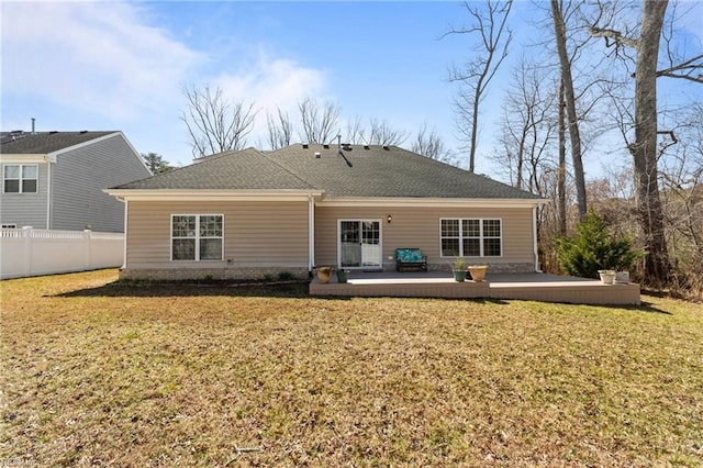 rear view of property featuring a deck, a yard, fence, and a shingled roof