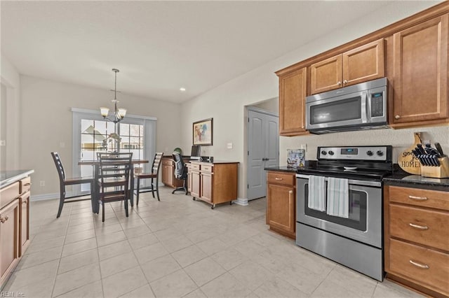 kitchen with baseboards, decorative light fixtures, brown cabinets, an inviting chandelier, and stainless steel appliances