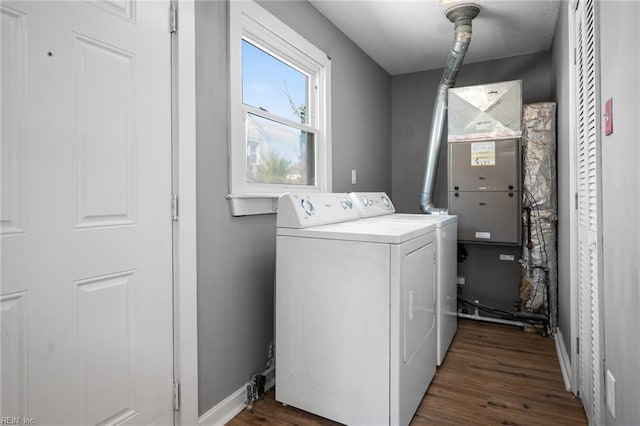 washroom featuring dark wood-style floors, baseboards, washing machine and dryer, and laundry area