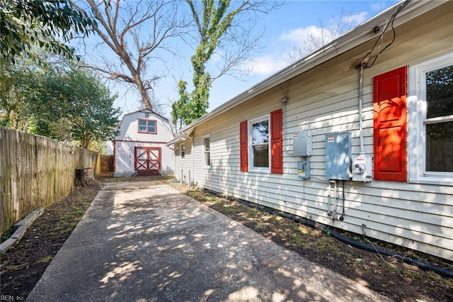 view of property exterior featuring an outbuilding, a storage shed, and fence