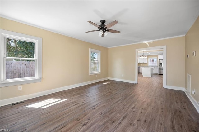 unfurnished living room with visible vents, ceiling fan with notable chandelier, baseboards, and wood finished floors