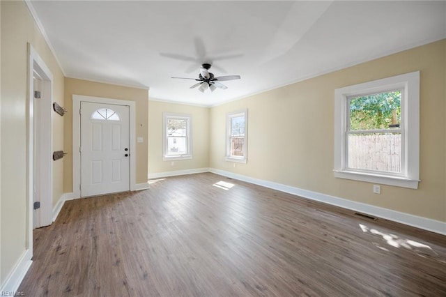 foyer with visible vents, wood finished floors, baseboards, and ornamental molding