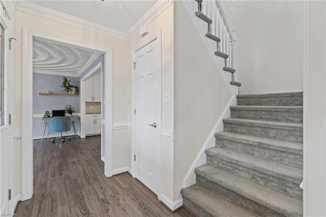 stairway featuring crown molding, baseboards, and wood finished floors