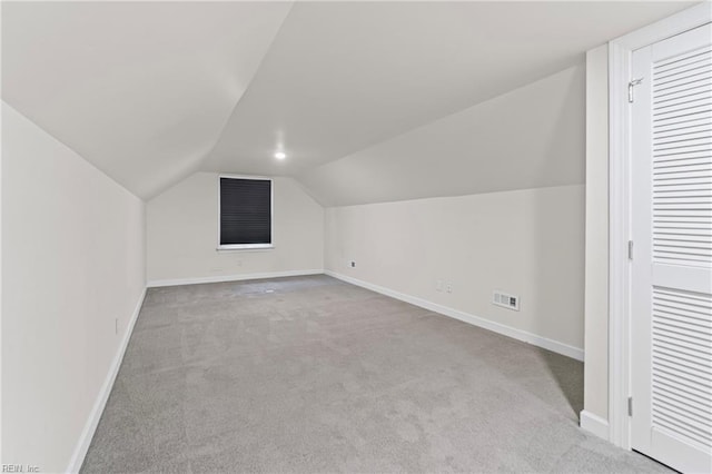 additional living space featuring carpet flooring, lofted ceiling, and baseboards