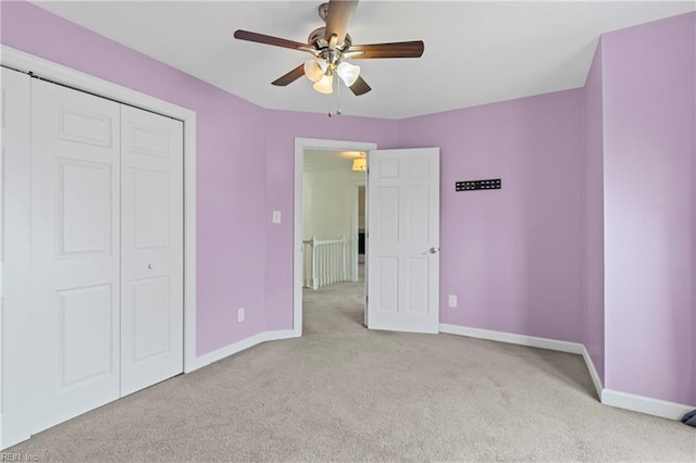 unfurnished bedroom featuring carpet flooring, baseboards, a closet, and ceiling fan