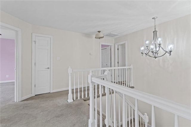 corridor with visible vents, baseboards, carpet, an upstairs landing, and an inviting chandelier