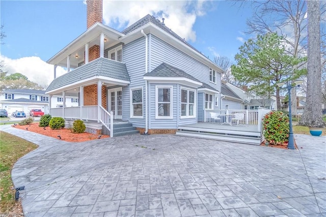 view of front of property with covered porch and a chimney