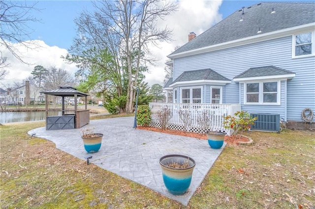 exterior space featuring a gazebo, cooling unit, a deck with water view, and a patio