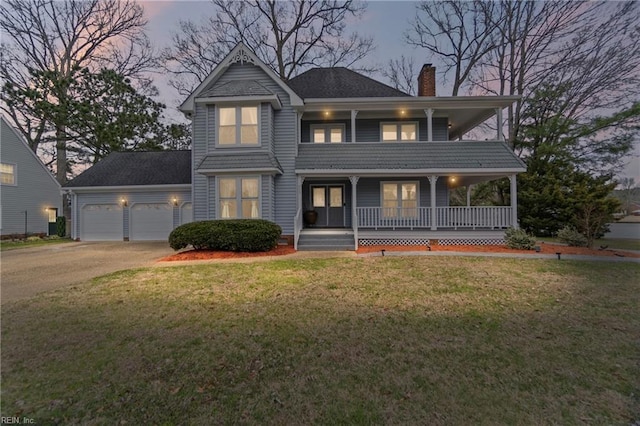 view of front of house featuring an attached garage, covered porch, a chimney, concrete driveway, and a lawn