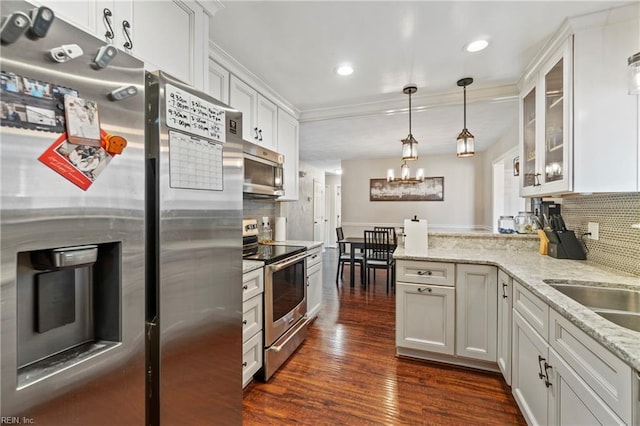 kitchen featuring glass insert cabinets, a peninsula, stainless steel appliances, dark wood-style floors, and white cabinetry