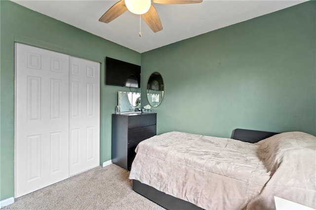 carpeted bedroom with a closet, a ceiling fan, and baseboards