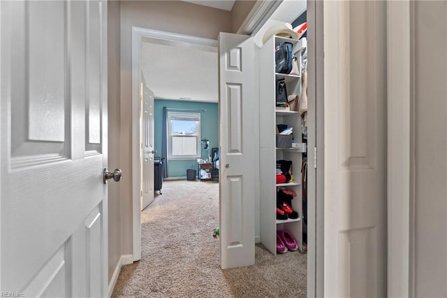 corridor featuring carpet flooring and baseboards