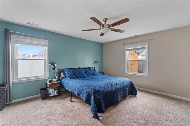 carpeted bedroom featuring visible vents, baseboards, a textured ceiling, and ceiling fan