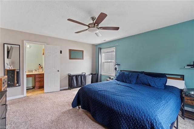 bedroom with light carpet, connected bathroom, baseboards, and ceiling fan