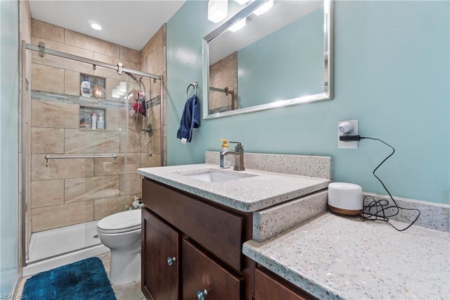 bathroom with vanity, a shower stall, and toilet