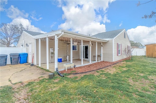 back of property with a patio area, fence, and a lawn