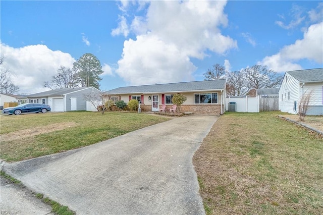 single story home with a front yard, fence, brick siding, and driveway