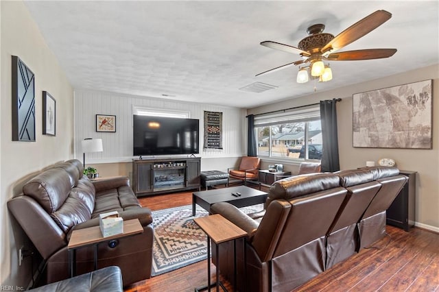 living area with visible vents, baseboards, ceiling fan, and wood finished floors